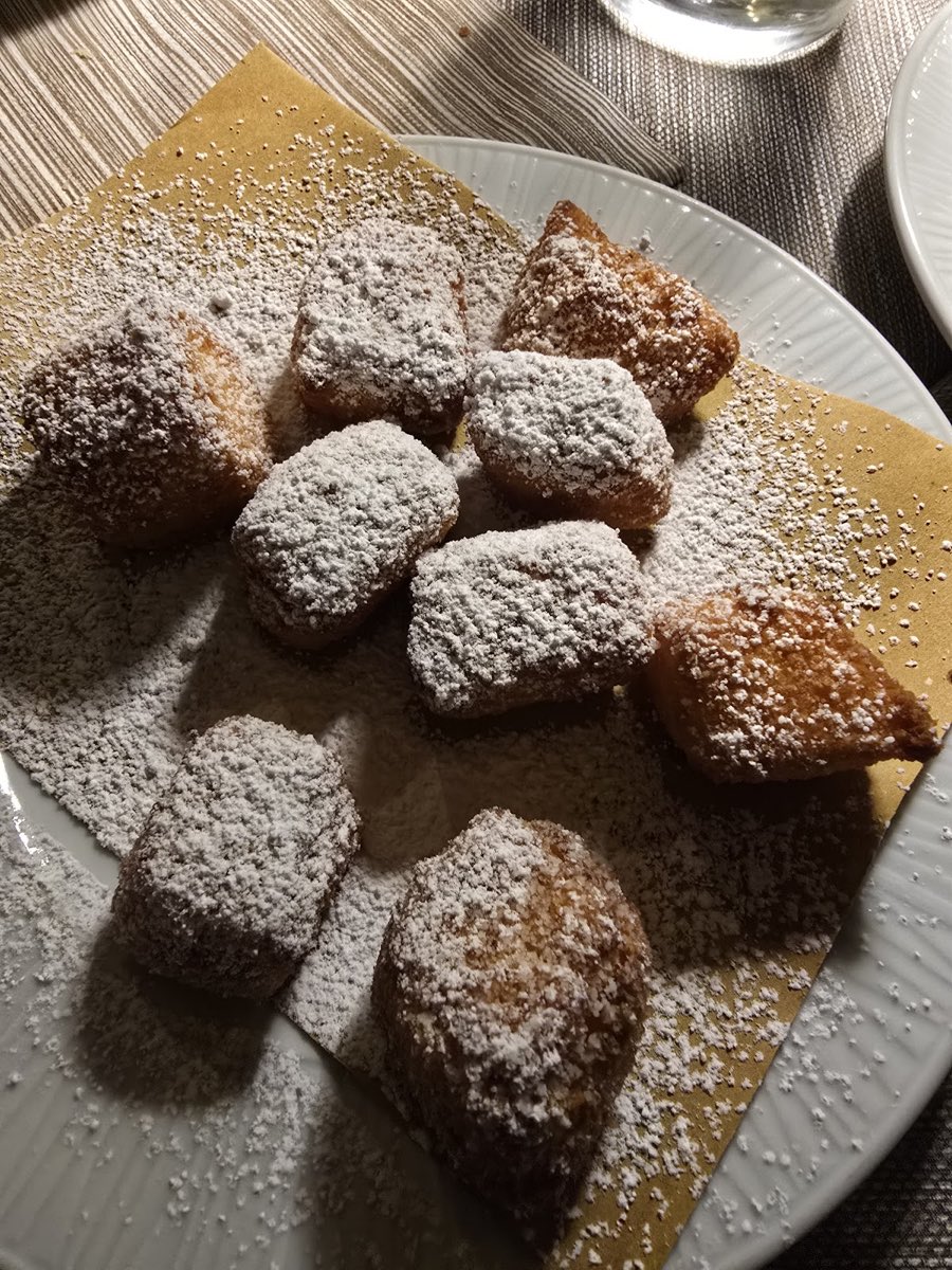 Bignè fritti spolverati di zucchero a velo, i dolci della casa